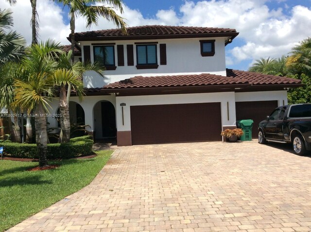21046 SW 133rd Ct, Miami, FL 33177 - mediterranean / spanish-style house featuring decorative driveway, a tile roof, stucco siding, and an attached garage