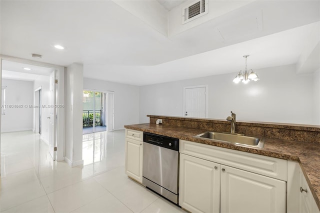 kitchen featuring dishwasher, a sink, dark countertops, light tile patterned floors, and a chandelier