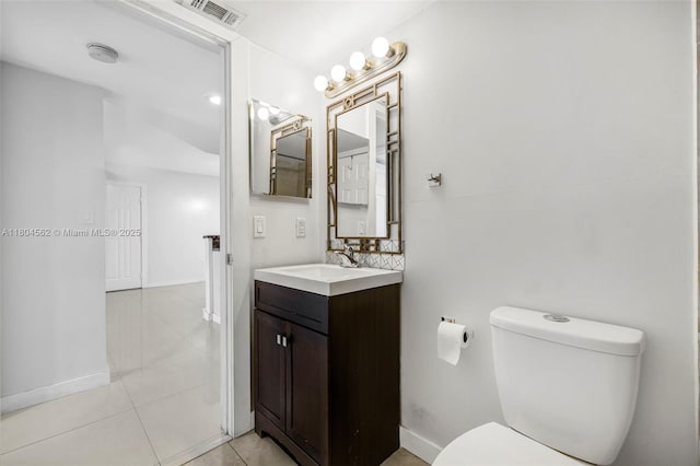 bathroom with toilet, vanity, tile patterned floors, and baseboards