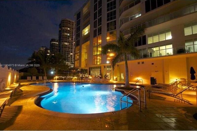 16699 Collins Ave Unit 3601, Sunny Isles Beach, FL 33160 - pool at night with a community pool and a patio