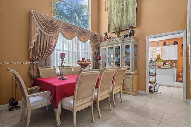15120 SW 156th Ave, Miami, FL 33196 - dining area featuring light tile patterned flooring, a high ceiling, and baseboards