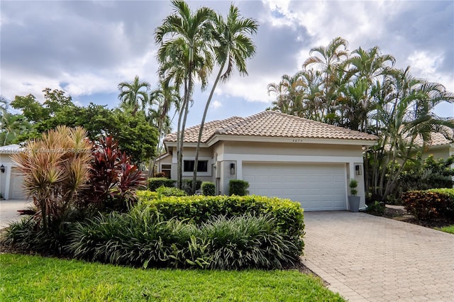 6670 NW 27th Ave, Boca Raton, FL 33496 - ranch-style home with a garage, decorative driveway, a tile roof, and stucco siding