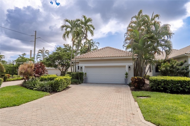 6670 NW 27th Ave, Boca Raton, FL 33496 - view of front of property featuring an attached garage, decorative driveway, stucco siding, a tile roof, and a front yard