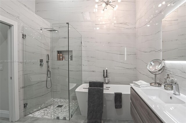 6670 NW 27th Ave, Boca Raton, FL 33496 - full bathroom featuring a marble finish shower, tile walls, a freestanding tub, vanity, and a chandelier