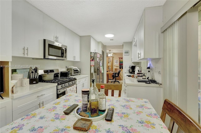13504 SW 68th Ter, Miami, FL 33183 - kitchen featuring appliances with stainless steel finishes, light countertops, white cabinets, and a textured ceiling