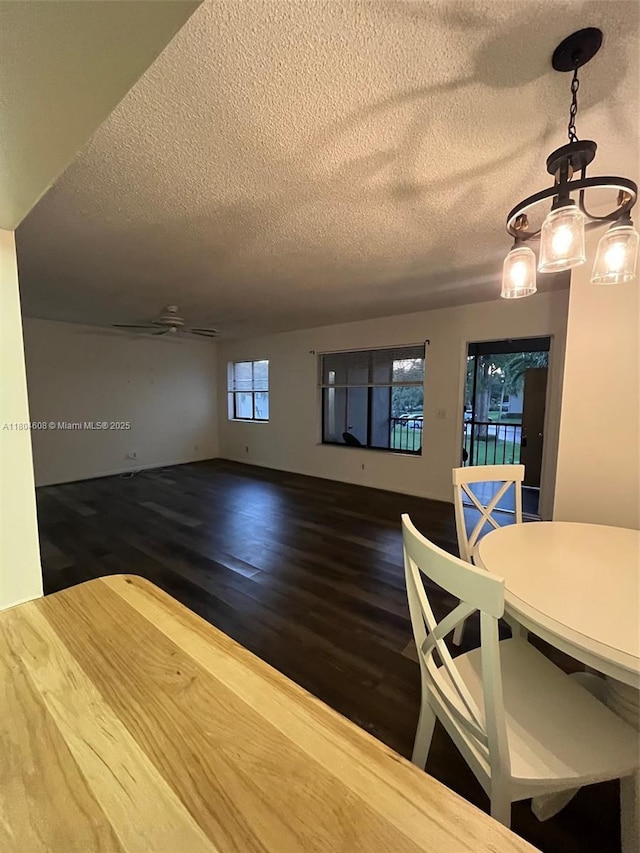 unfurnished dining area featuring a textured ceiling and wood finished floors