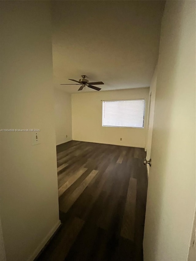 empty room featuring dark wood finished floors and a ceiling fan