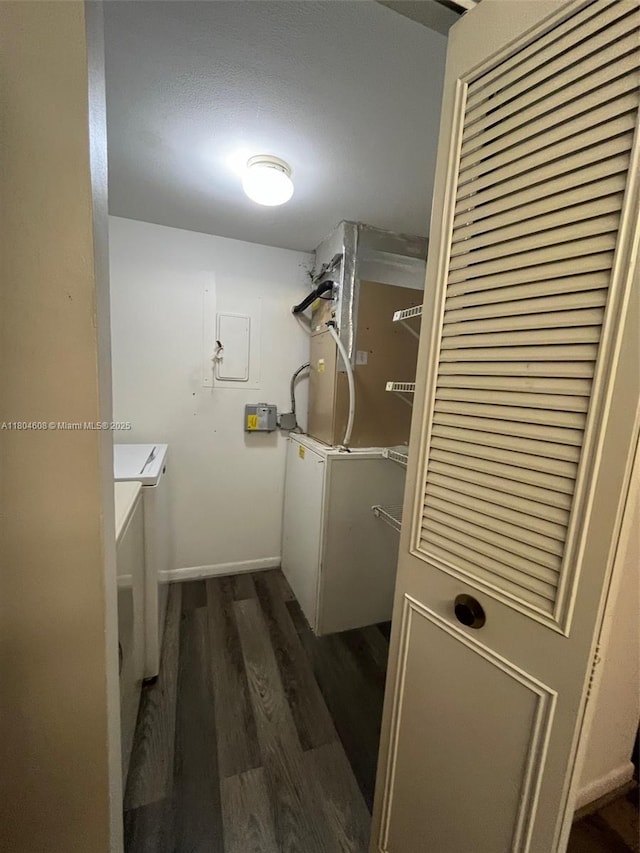 washroom with dark wood finished floors, washer / dryer, and baseboards