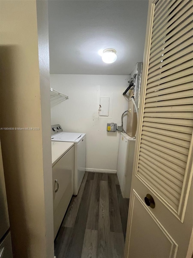 washroom with washing machine and clothes dryer, dark wood-style floors, and baseboards