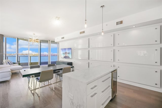 2020 N Bayshore Dr Unit 2001, Miami, FL 33137 - kitchen with dark wood-style floors, floor to ceiling windows, a water view, white cabinets, and decorative light fixtures
