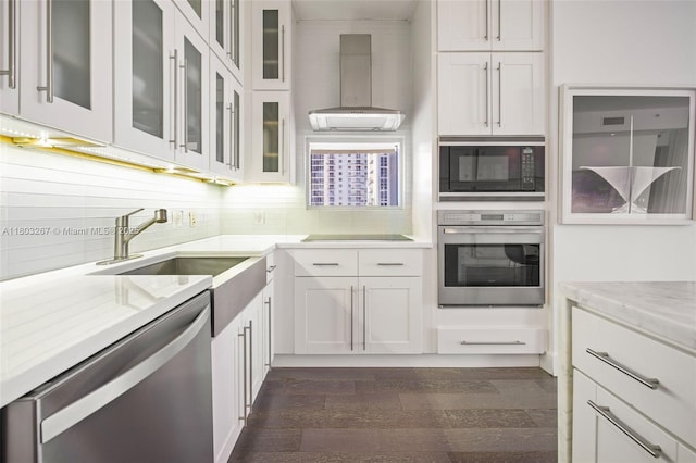 2020 N Bayshore Dr Unit 2001, Miami, FL 33137 - kitchen featuring black appliances, wall chimney exhaust hood, backsplash, dark wood-style floors, and white cabinetry
