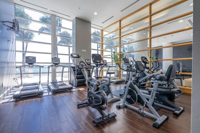 665 NE 25th St Unit 405, Miami, FL 33137 - workout area featuring expansive windows, a towering ceiling, and wood finished floors