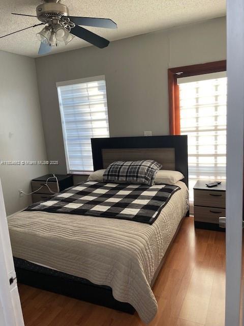 8340 NW 8th St Unit N12, Miami, FL 33126 - bedroom featuring wood finished floors, a textured ceiling, and ceiling fan