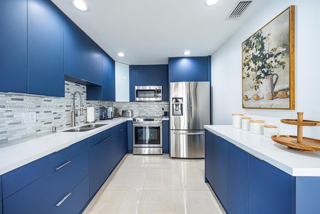 6950 NW 168th St, Hialeah, FL 33015 - kitchen featuring appliances with stainless steel finishes, blue cabinets, decorative backsplash, light countertops, and light tile patterned floors
