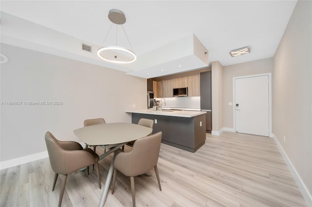 951 Brickell Ave Unit 2800, Miami, FL 33131 - dining area featuring light wood-style floors, baseboards, and a raised ceiling