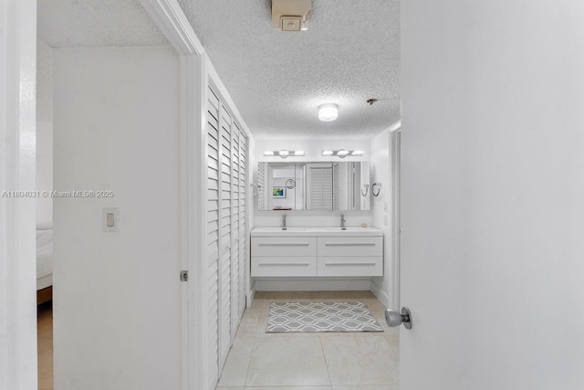 20355 NE 34th Ct Unit 929, Aventura, FL 33180 - bathroom featuring a textured ceiling, double vanity, and tile patterned flooring