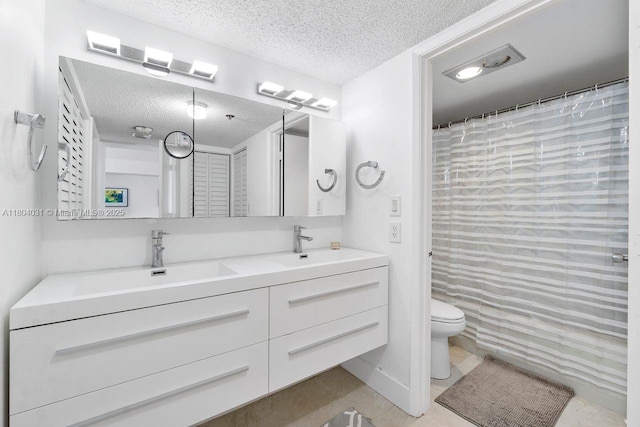 20355 NE 34th Ct Unit 929, Aventura, FL 33180 - bathroom featuring a textured ceiling, tile patterned flooring, toilet, and double vanity