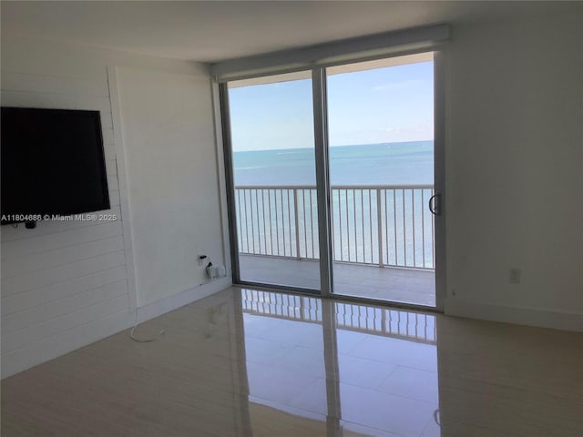 150 SE 25th Rd Unit 14H, Miami, FL 33129 - tiled empty room featuring view of water and beach and baseboards