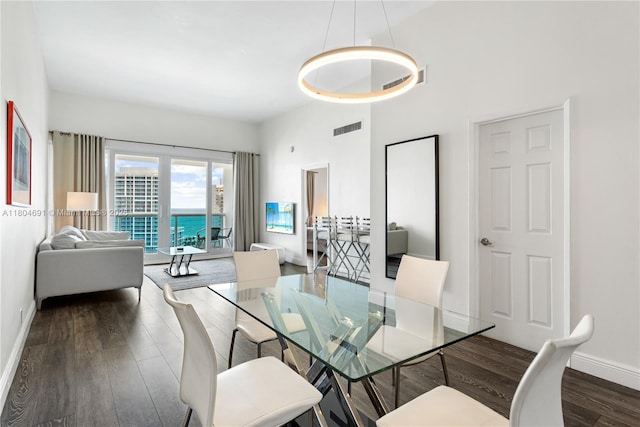 6770 Indian Creek Dr Unit Tsa1, Miami Beach, FL 33141 - dining space featuring wood finished floors, baseboards, and a towering ceiling
