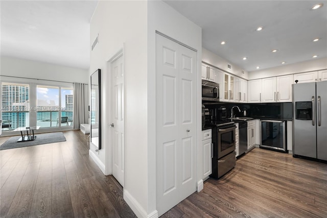 6770 Indian Creek Dr Unit Tsa1, Miami Beach, FL 33141 - kitchen featuring appliances with stainless steel finishes, dark wood-style floors, dark countertops, white cabinets, and recessed lighting