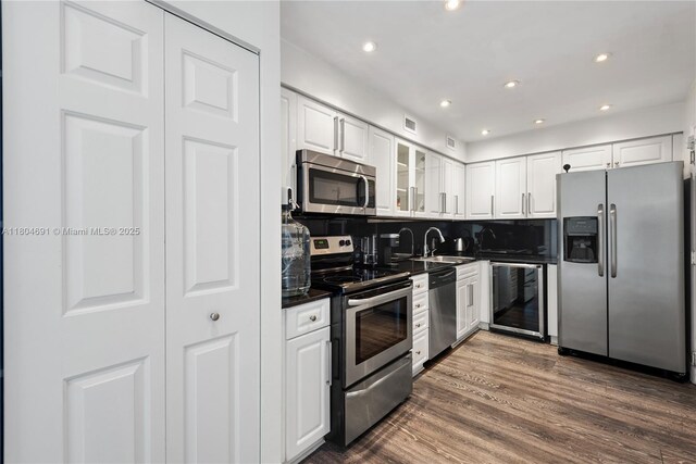 6770 Indian Creek Dr Unit Tsa1, Miami Beach, FL 33141 - kitchen featuring stainless steel appliances, wine cooler, dark countertops, white cabinets, and recessed lighting