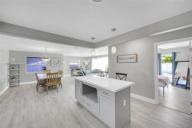1950 NE 55th Ct, Fort Lauderdale, FL 33308 - kitchen featuring light wood-type flooring, pendant lighting, light countertops, and baseboards