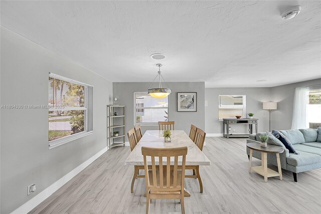 1950 NE 55th Ct, Fort Lauderdale, FL 33308 - dining space with baseboards, light wood-style flooring, and a textured ceiling