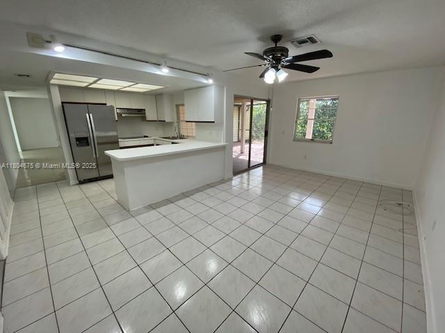 14953 SW 143rd Ct, Miami, FL 33186 - kitchen with stainless steel fridge, exhaust hood, light countertops, a peninsula, and open floor plan