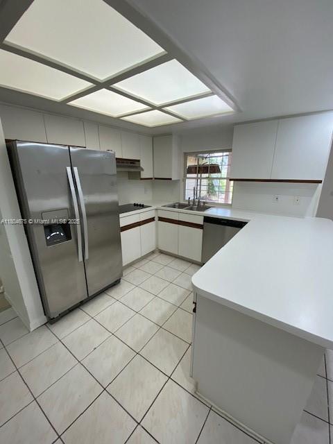 14953 SW 143rd Ct, Miami, FL 33186 - kitchen featuring appliances with stainless steel finishes, a sink, light countertops, light tile patterned floors, and a peninsula