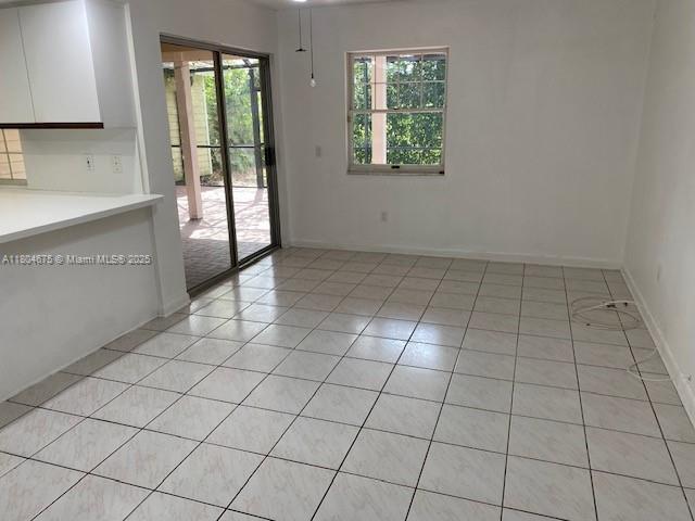 14953 SW 143rd Ct, Miami, FL 33186 - unfurnished dining area featuring light tile patterned flooring and baseboards