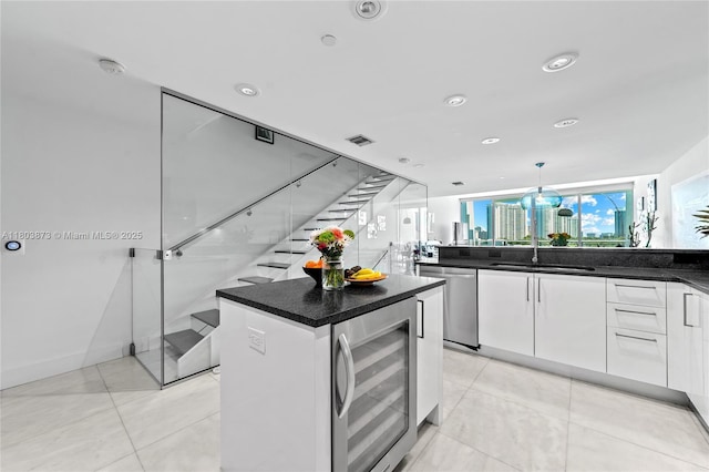2950 NE 188th St Unit 540, Aventura, FL 33180 - kitchen featuring wine cooler, white cabinetry, dishwasher, a kitchen island, and light tile patterned floors
