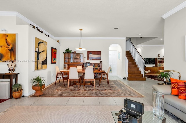 2626 Sawyer Ter, Wellington, FL 33414 - dining space featuring light tile patterned floors, crown molding, arched walkways, stairway, and baseboards