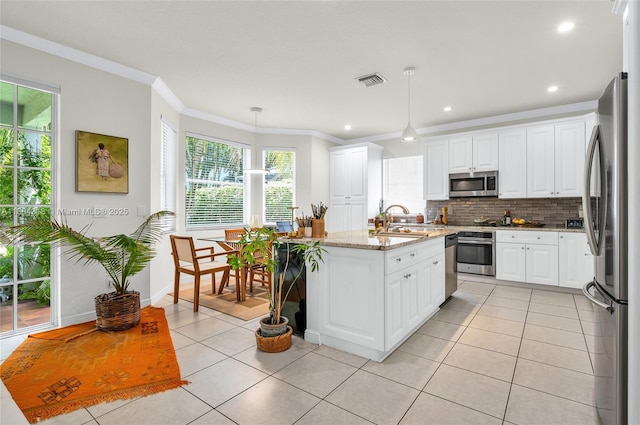 2626 Sawyer Ter, Wellington, FL 33414 - kitchen featuring appliances with stainless steel finishes, light tile patterned floors, tasteful backsplash, healthy amount of natural light, and ornamental molding