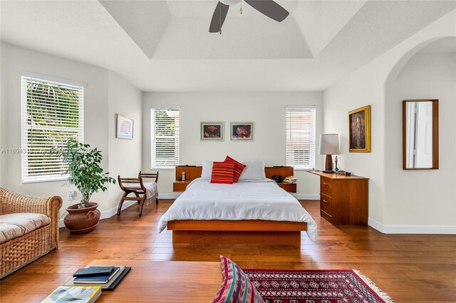 2626 Sawyer Ter, Wellington, FL 33414 - bedroom with wood-type flooring, arched walkways, multiple windows, and baseboards