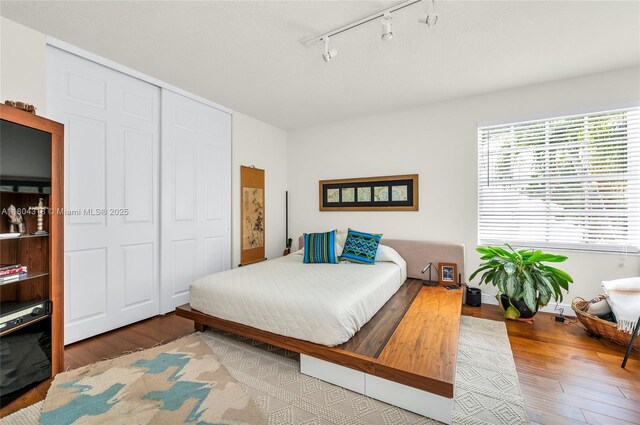2626 Sawyer Ter, Wellington, FL 33414 - bedroom featuring wood finished floors, rail lighting, and a closet