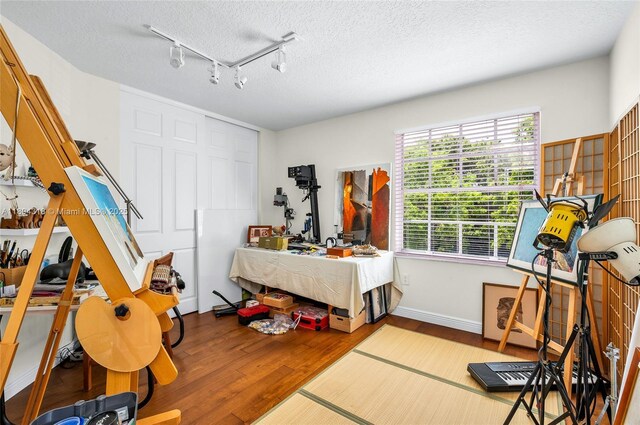 2626 Sawyer Ter, Wellington, FL 33414 - bedroom featuring wood finished floors, a textured ceiling, track lighting, and baseboards