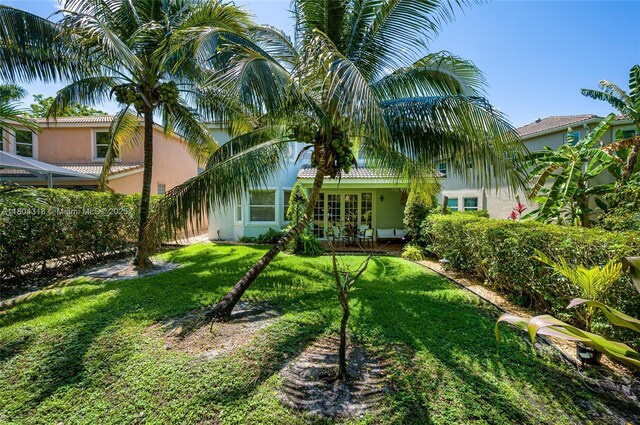 2626 Sawyer Ter, Wellington, FL 33414 - rear view of house with stucco siding, a yard, french doors, and a tile roof