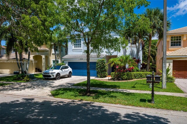2626 Sawyer Ter, Wellington, FL 33414 - view of front of house featuring driveway, stucco siding, a tile roof, and an attached garage
