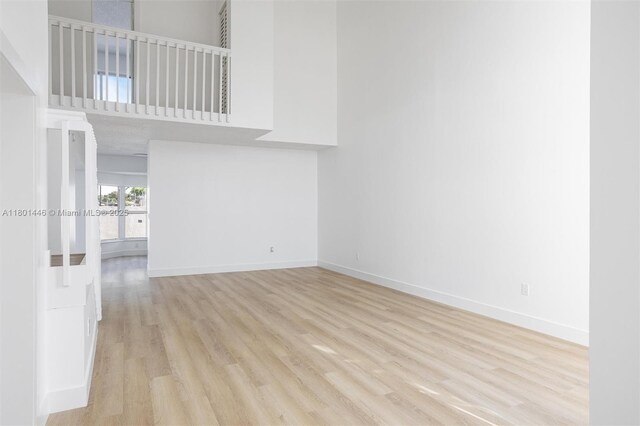 8501 NW 191st St, Hialeah, FL 33015 - unfurnished living room featuring wood finished floors, baseboards, a high ceiling, and french doors