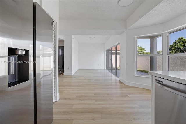 8501 NW 191st St, Hialeah, FL 33015 - hallway featuring light wood finished floors, baseboards, and a textured ceiling