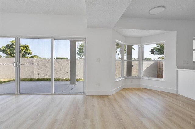 8501 NW 191st St, Hialeah, FL 33015 - spare room featuring wood finished floors, plenty of natural light, baseboards, and a textured ceiling