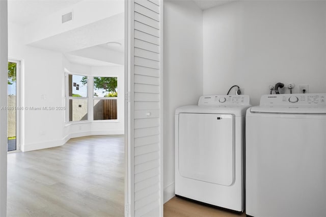 8501 NW 191st St, Hialeah, FL 33015 - laundry room with light wood-style floors, washer and clothes dryer, and baseboards
