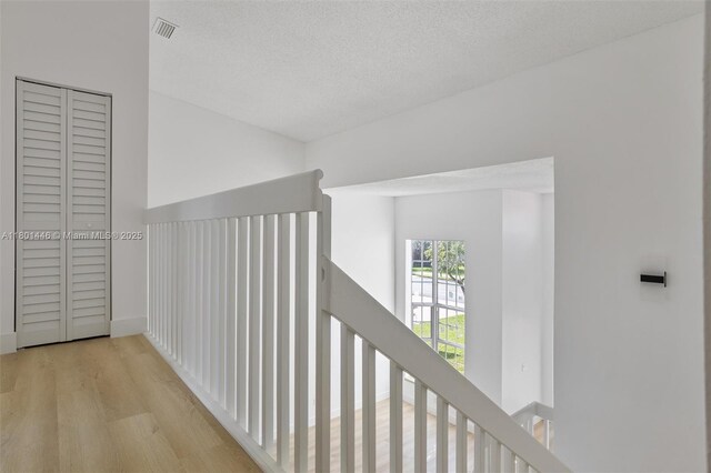 8501 NW 191st St, Hialeah, FL 33015 - hall featuring an upstairs landing, wood finished floors, and a textured ceiling