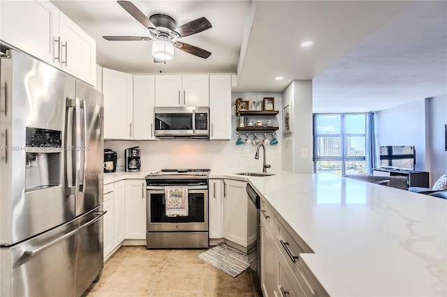 2017 S Ocean Dr Unit 1404, Hallandale Beach, FL 33009 - kitchen featuring appliances with stainless steel finishes, a sink, white cabinets, open shelves, and tasteful backsplash