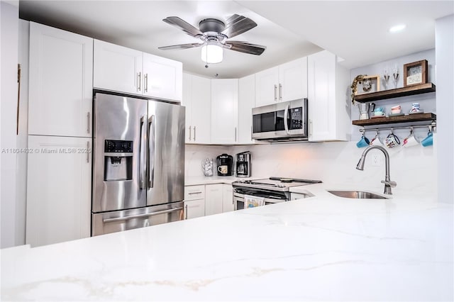 2017 S Ocean Dr Unit 1404, Hallandale Beach, FL 33009 - kitchen featuring appliances with stainless steel finishes, a sink, open shelves, light stone countertops, and a ceiling fan