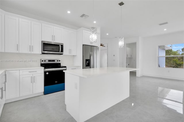 935 Elgin St, Lehigh Acres, FL 33974 - kitchen featuring stainless steel appliances, a kitchen island, recessed lighting, light countertops, and white cabinetry
