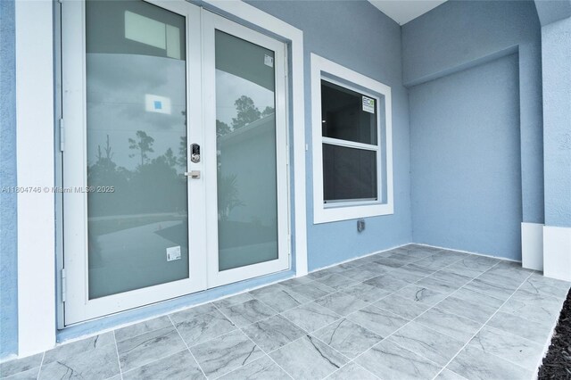 935 Elgin St, Lehigh Acres, FL 33974 - doorway to property with stucco siding and french doors