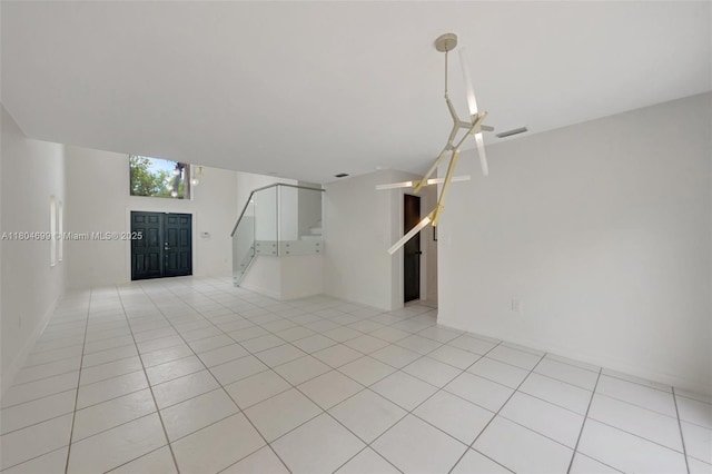 unfurnished room featuring stairway and light tile patterned floors