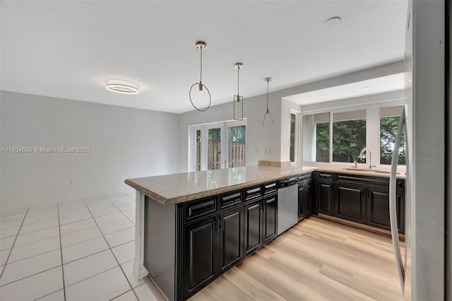 kitchen featuring appliances with stainless steel finishes, a sink, french doors, dark cabinets, and pendant lighting