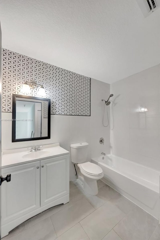bathroom with toilet, a textured ceiling,  shower combination, and vanity